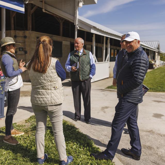 people standing outside barn